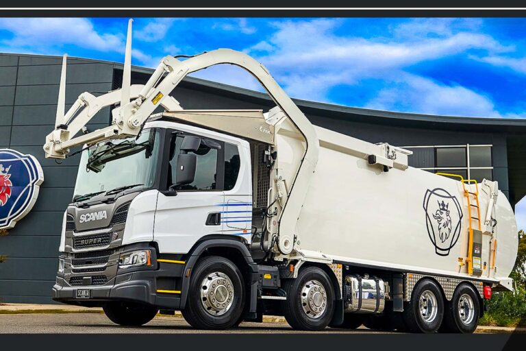 scania-super-11-p390-front-lift-refuse-truck-australia White Scania Super 11 P390 front-lift refuse truck parked with its lifting arms positioned above the cab.